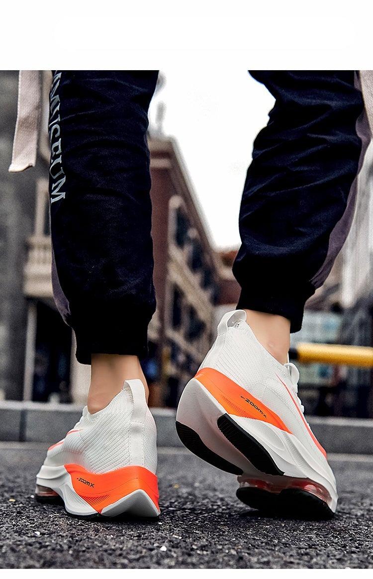 Men's athletic sneakers white knit upper with orange heel accents and air cushion midsole on Tampa Home & Garden Store