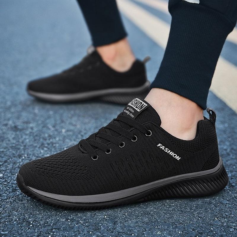 Two black Stevvex men's fashion sneakers with breathable knit upper and non-slip sole on Tampa Home & Garden Store