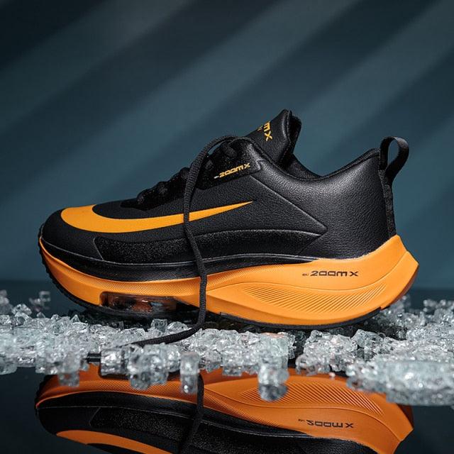 Stevvex mens running sneakers black upper with orange outsole and logo on ice reflection on Tampa Home & Garden Store