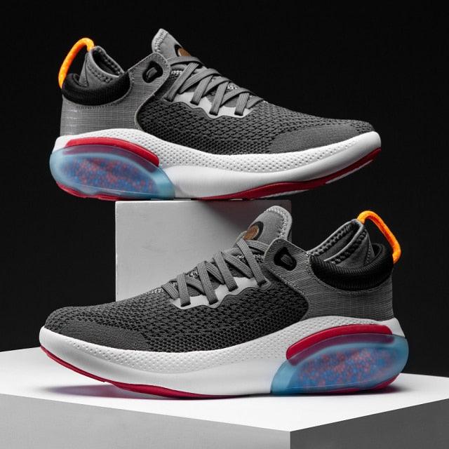 Two men's grey knit running sneakers with white midsole and orange pull tab, blue heel pod on Tampa Home & Garden Store