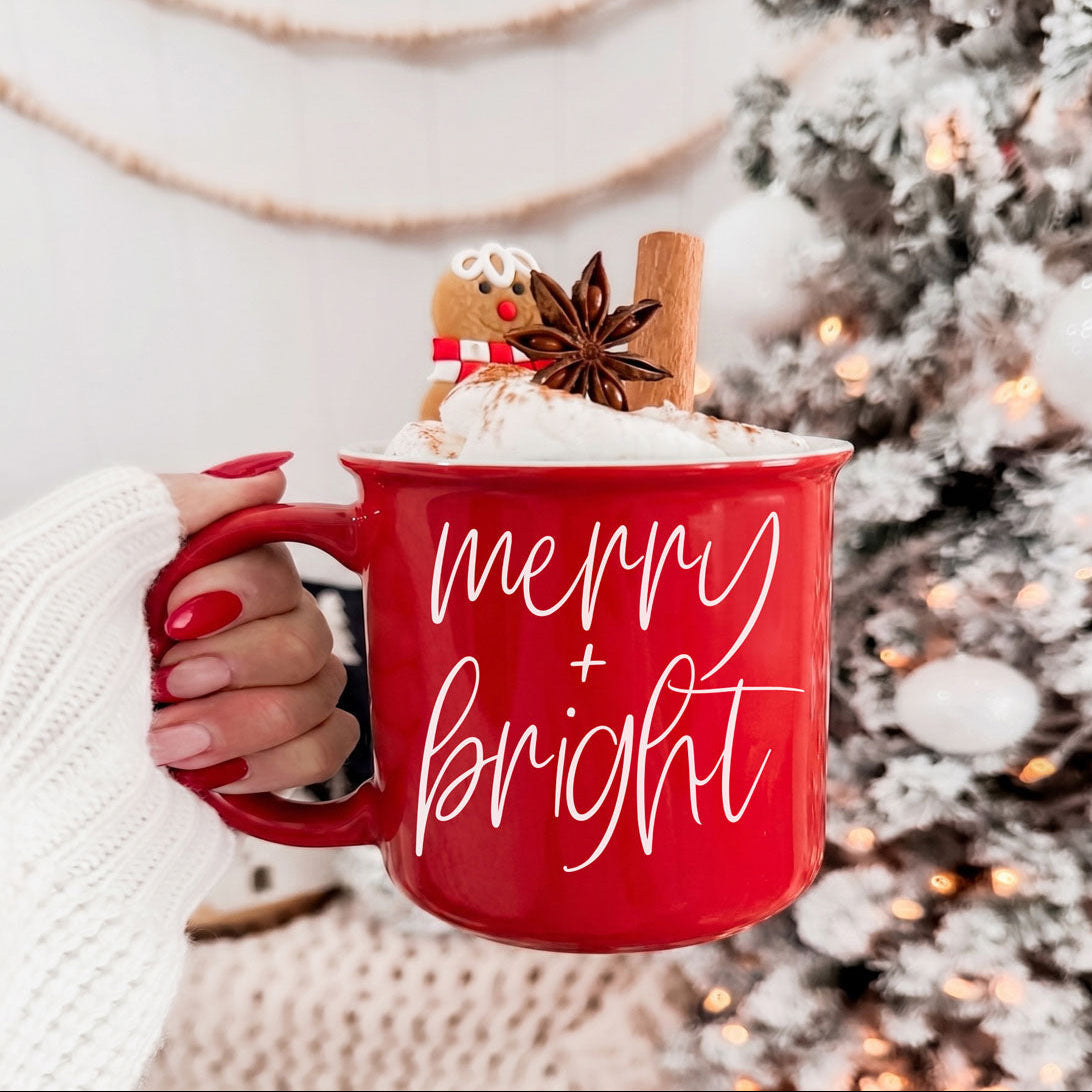 Gia Roma Merry & Bright red coffee mug with script, topped with whipped cream and cinnamon stick on Tampa Home & Garden Store