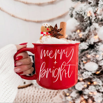Gia Roma Merry & Bright red coffee mug with script, topped with whipped cream and cinnamon stick on Tampa Home & Garden Store