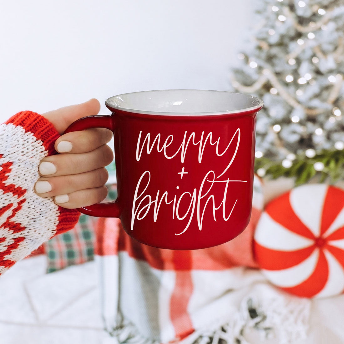 Merry & Bright Gia Roma coffee mug in red with white cursive text held in hand on Tampa Home & Garden Store