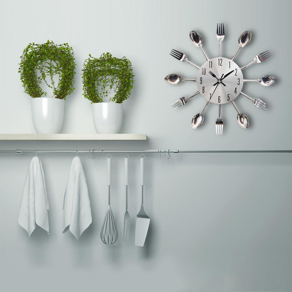 Metal kitchen wall clock with cutlery design featuring spoon and fork accents, silver finish on Tampa Home & Garden Store