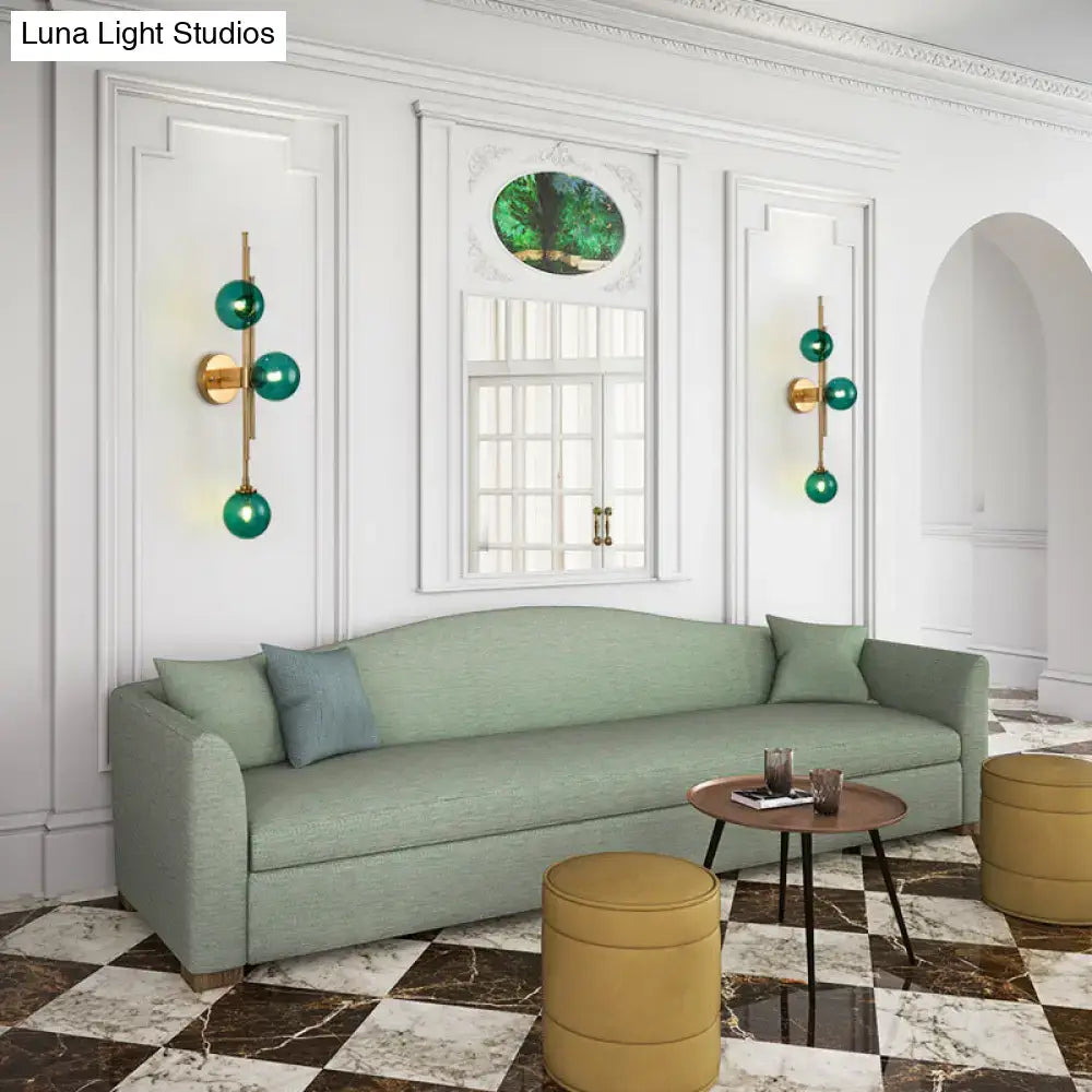 Brass Glass Orb Sconce pair with emerald glass spheres on white wall Decorbites on Tampa Home & Garden Store