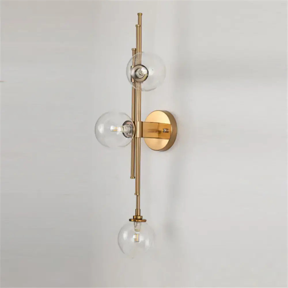 Brass glass orb sconce with tall brass rod and three clear globes wall mounted by Decorbites on Tampa Home & Garden Store