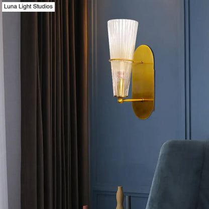 Brass ribbed glass wall lamp sconce with gold backplate on blue wall on Tampa Home & Garden Store