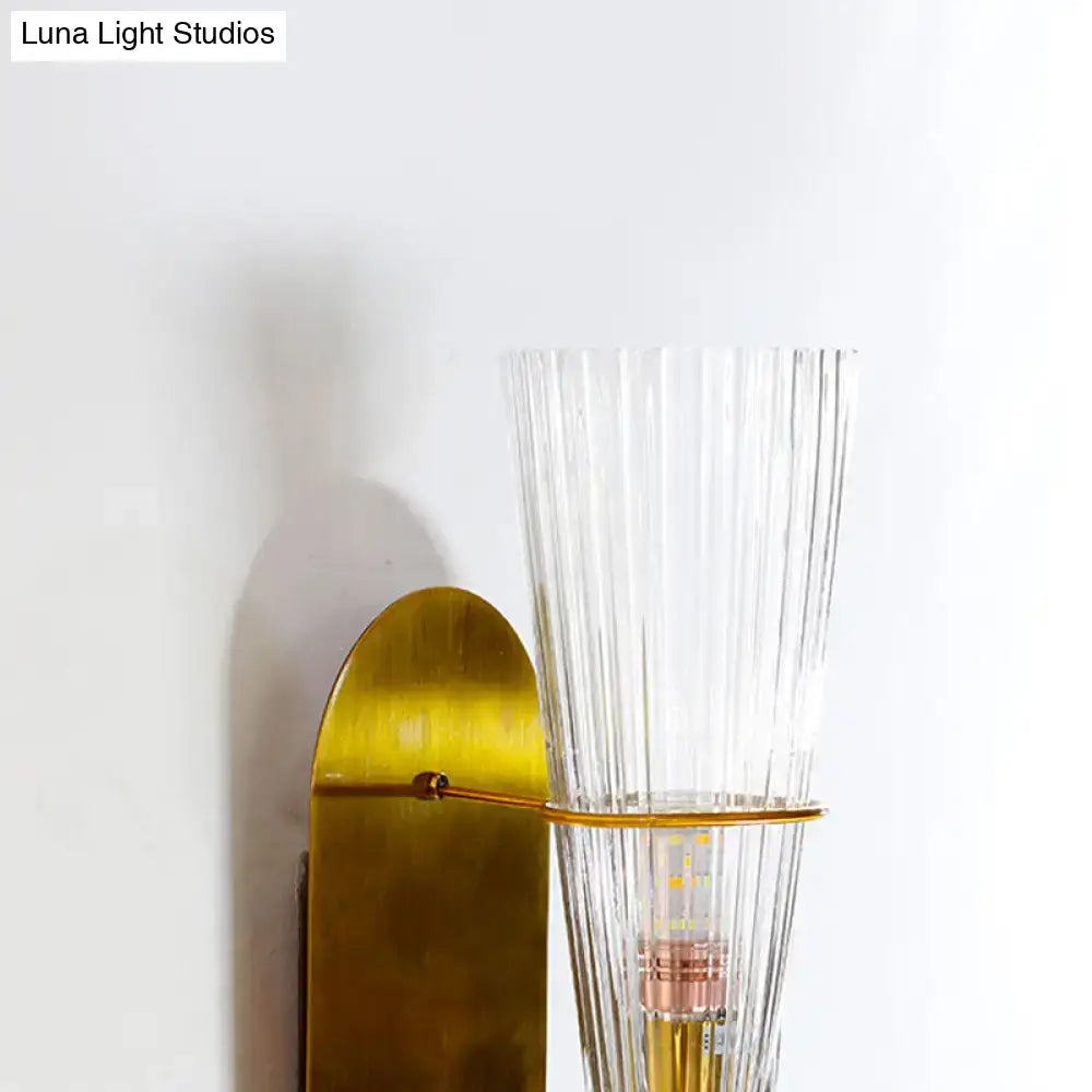 Brass ribbed glass wall lamp with tall clear shade, wall-mounted fixture on Tampa Home & Garden Store