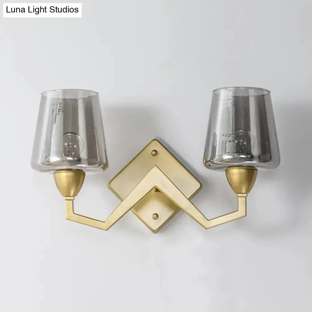 Mid-century brass double-sconce wall lamp with clear truncated cone glass shades on backplate on Tampa Home & Garden Store