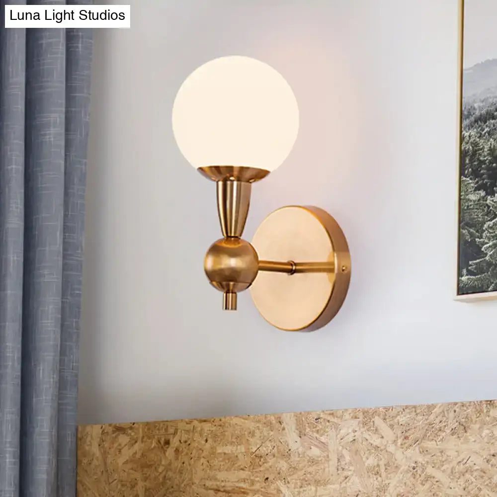 Brass opal glass orb wall sconce with round backplate and arm by Decorbites on Tampa Home & Garden Store