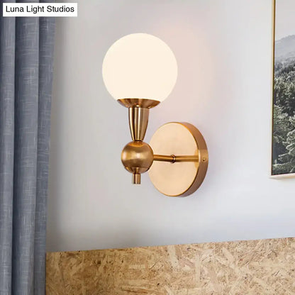 Brass opal glass orb wall sconce with round backplate and arm by Decorbites on Tampa Home & Garden Store