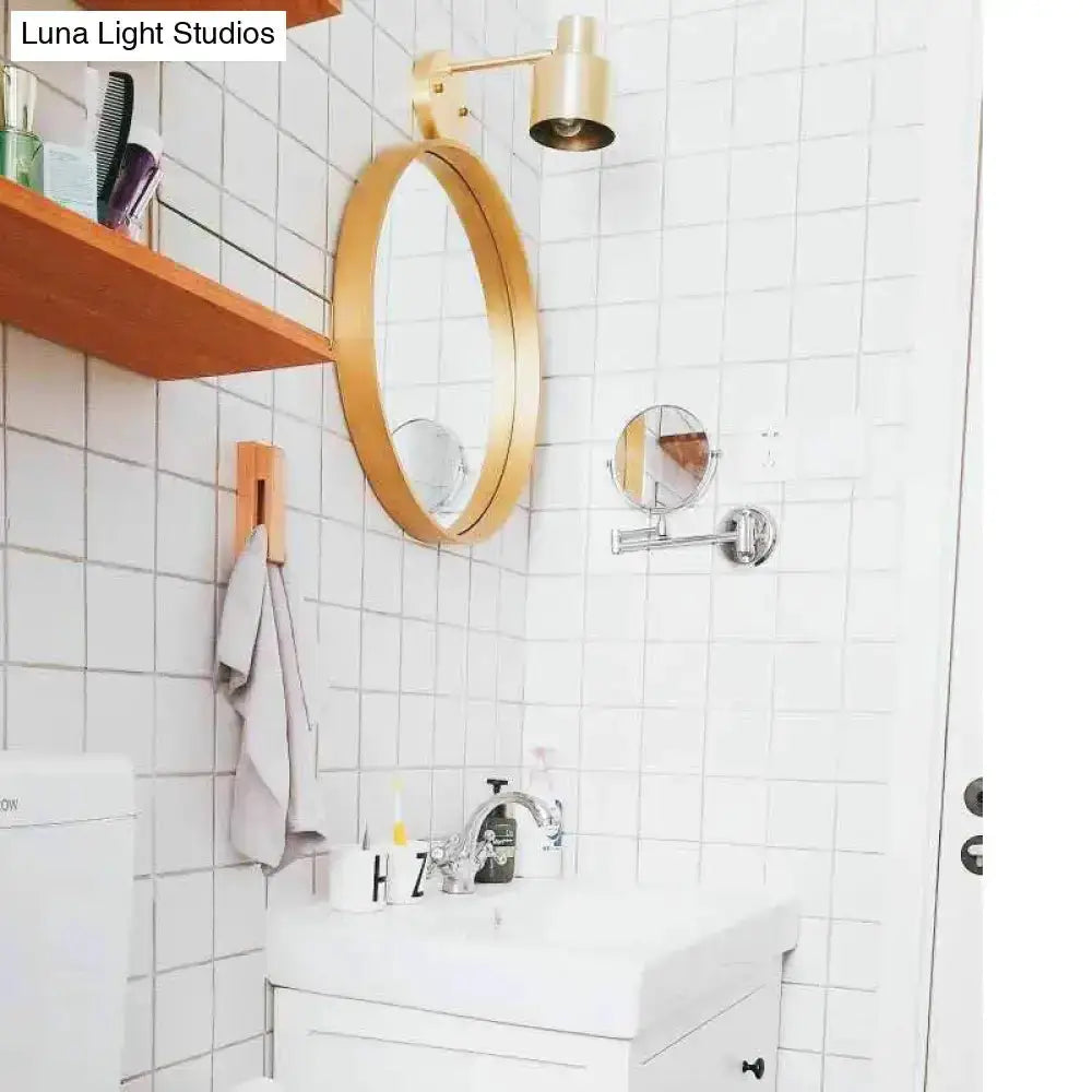 Mid-century gold metal cage wall sconce with round gold mirror above bathroom Decorbites on Tampa Home & Garden Store
