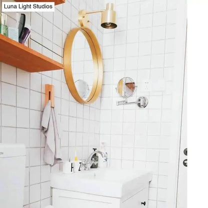 Mid-century gold metal cage wall sconce with round gold mirror above bathroom Decorbites on Tampa Home & Garden Store
