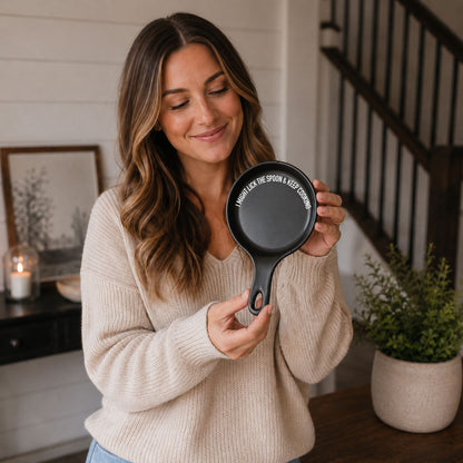 Lick the Spoon & Cook spoon rest, black with white slogan, held by woman in beige sweater on Tampa Home & Garden Store