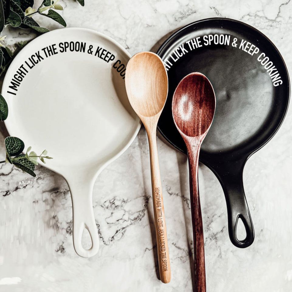 Lick the Spoon & Cook spoon rests by Gia Roma: white and black ceramic with bold rim text and wooden spoons on Tampa Home & Garden Store