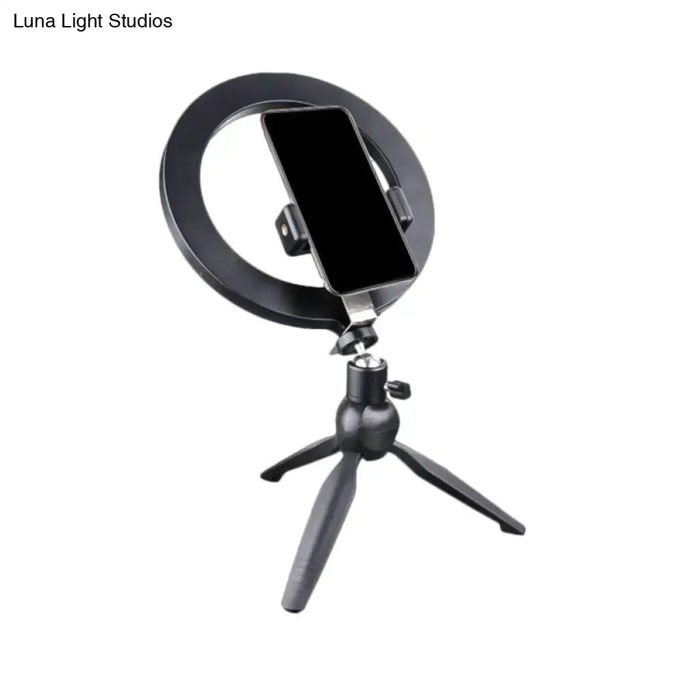 Black metal phone holder with circular ring mount on an adjustable tripod on Tampa Home & Garden Store