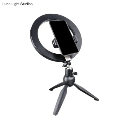 Black metal phone holder with circular ring mount on an adjustable tripod on Tampa Home & Garden Store