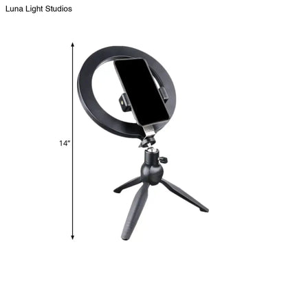 Black metal phone holder with circular ring mount on a small tripod stand on Tampa Home & Garden Store