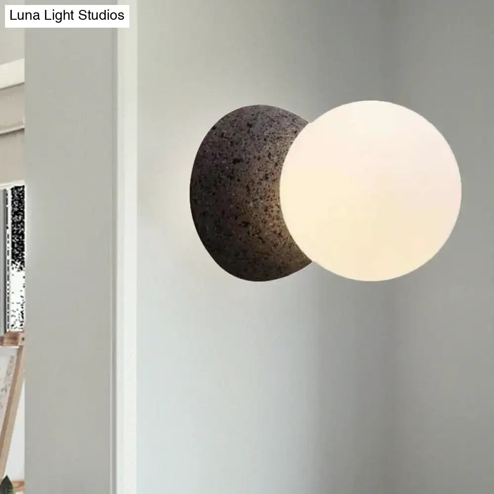 Black glass minimalist LED wall sconce with white frosted globe and dark back sphere on Tampa Home & Garden Store