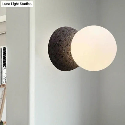 Black glass minimalist LED wall sconce with white frosted globe and dark back sphere on Tampa Home & Garden Store