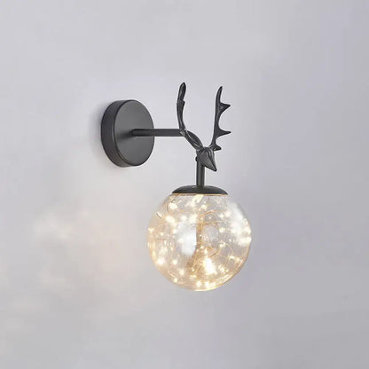 Black antler glass sconce with round illuminated globe and warm string lights on Tampa Home & Garden Store