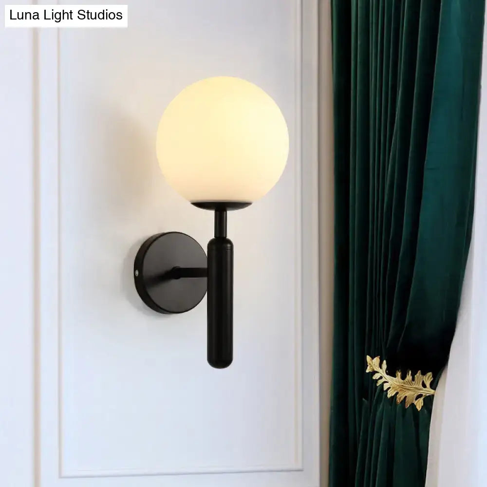 Black ball wall sconce by Decorbites with frosted glass globe and round backplate on Tampa Home & Garden Store