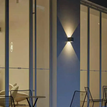 Grey cement square wall lamp by Decorbites on a blue wall, casts upward and downward light on Tampa Home & Garden Store