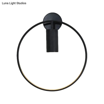 Black circular metal wall sconce with a large ring frame and a cylindrical mount on Tampa Home & Garden Store