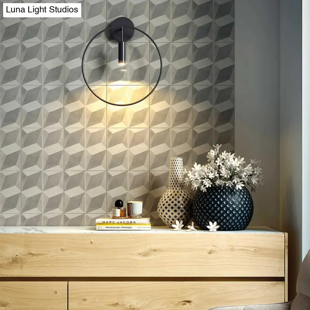 Black circular metal wall sconce with ring frame and warm light on Tampa Home & Garden Store