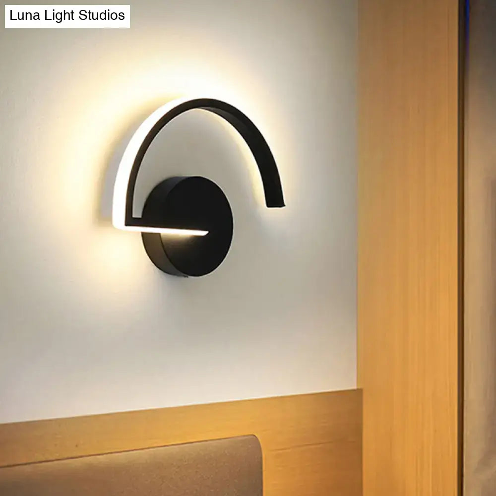 Black curved open-frame wall sconce with circular base and arching arm by Decorbites, emits soft ambient LED glow on Tampa Home & Garden Store