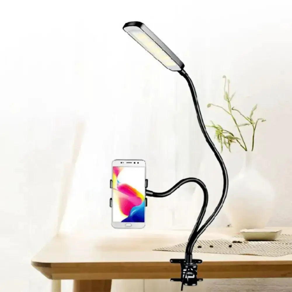 Minimalist black flexible-arm desk lamp with phone holder mounted on desk clamp on Tampa Home & Garden Store