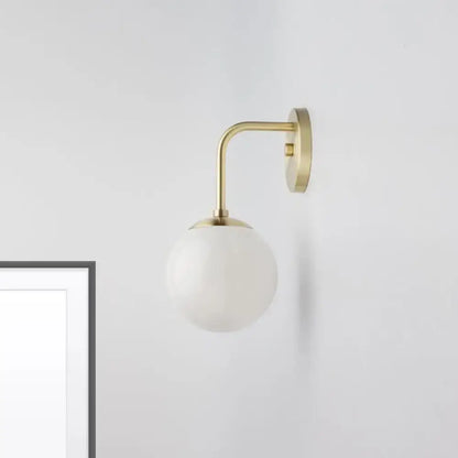 Milky Glass Ball Wall Lamp by Decorbites; brass curved arm, white glass globe, wall-mounted on Tampa Home & Garden Store
