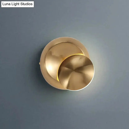 Moon-shaped brass wall sconce with overlapping discs and warm glow on blue wall on Tampa Home & Garden Store