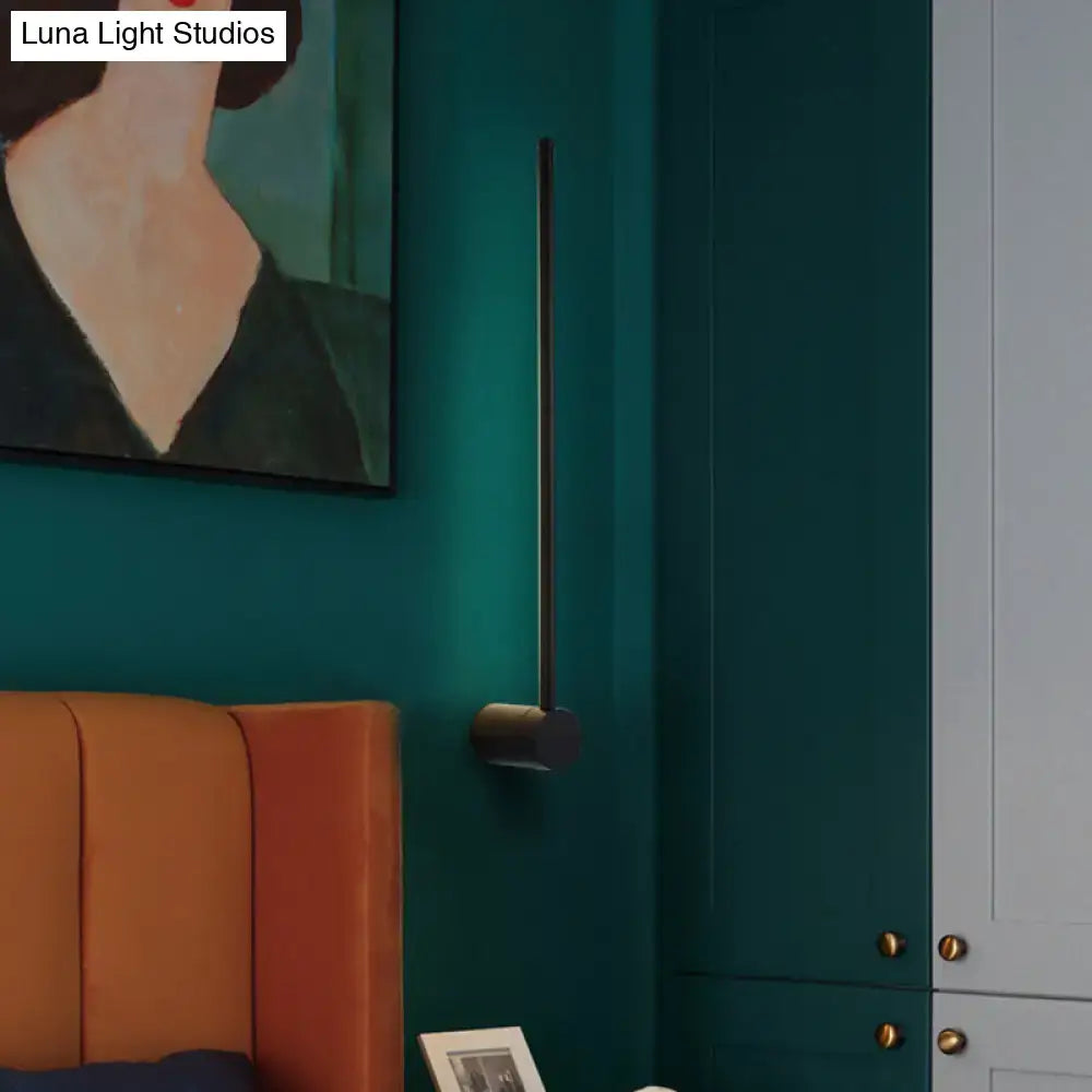 Black Needle Wall Light, slim metal rod sconce on teal wall with round mount on Tampa Home & Garden Store