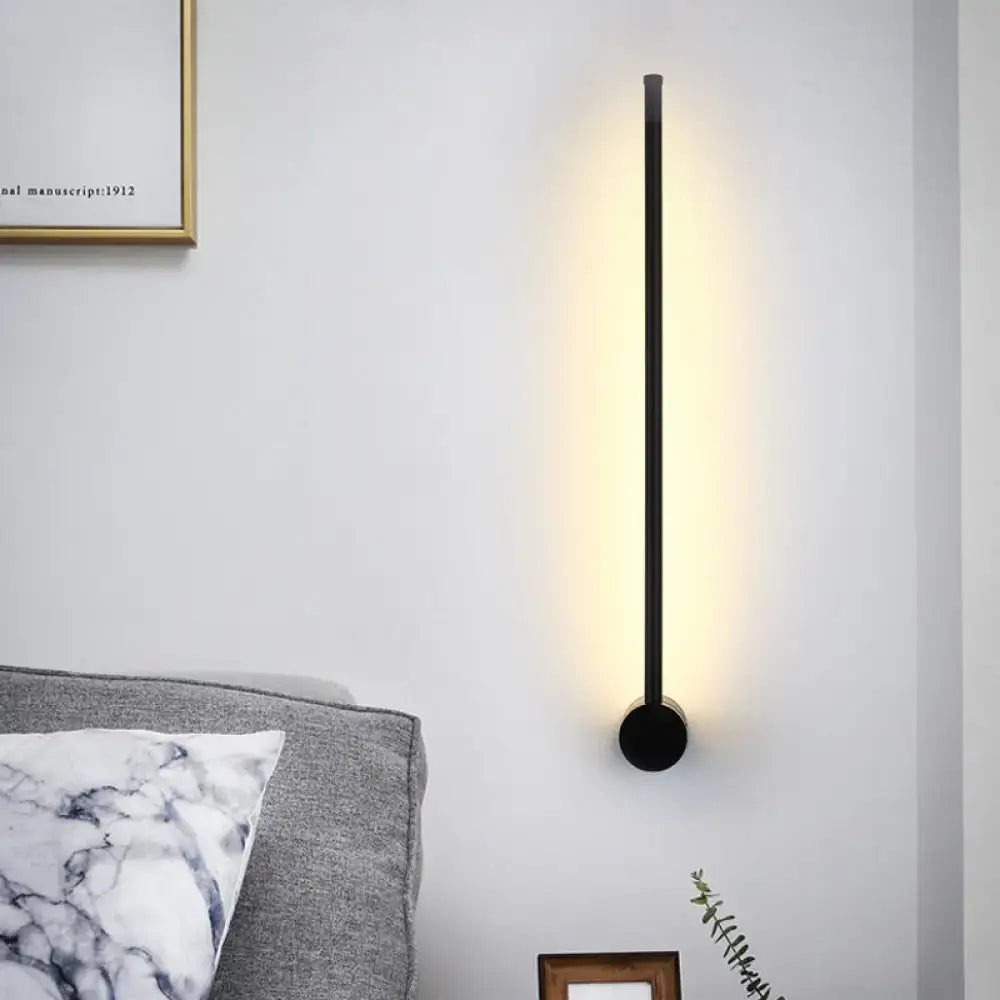 Black Needle Wall Light by Decorbites; slim black metal vertical sconce with warm glow on Tampa Home & Garden Store