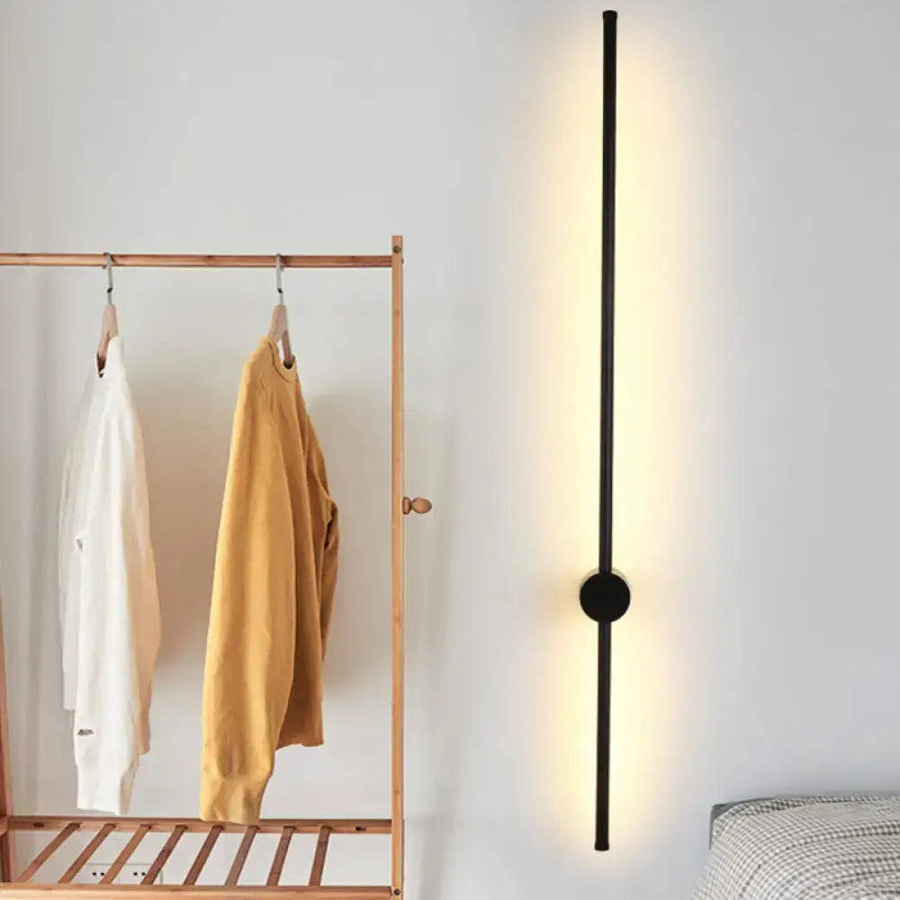 Decorbites Black Needle Wall Light, slim black vertical LED fixture with warm ambient glow on Tampa Home & Garden Store