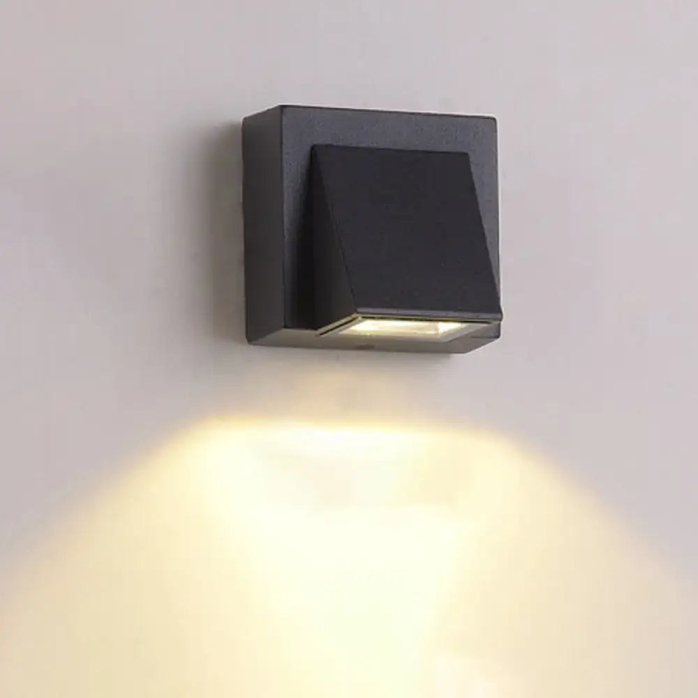 Black triangle wall lamp; metal square backplate by Decorbites, shade, downward warm light on Tampa Home & Garden Store