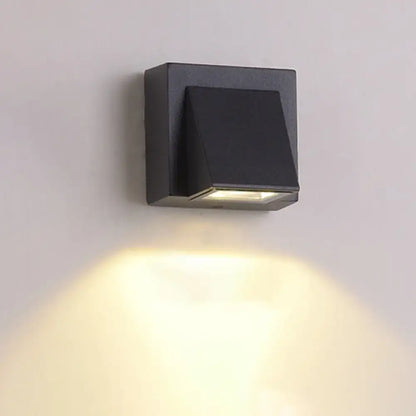 Black triangle wall lamp; metal square backplate by Decorbites, shade, downward warm light on Tampa Home & Garden Store