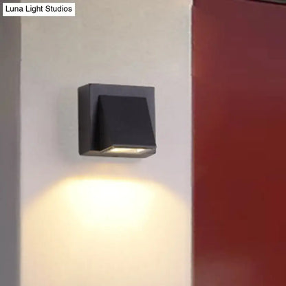 Black triangle wall lamp Decorbites wall sconce casting warm downward light on Tampa Home & Garden Store