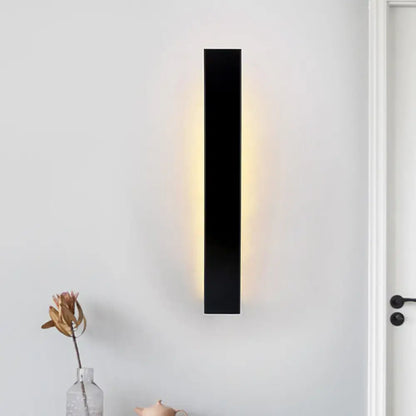 White aluminum wall sconce by Decorbites; vertical LED fixture with warm glow on Tampa Home & Garden Store