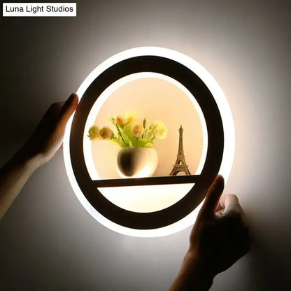 White circular LED sconce by Decorbites with black ring; shelf shows vase and Eiffel Tower on Tampa Home & Garden Store