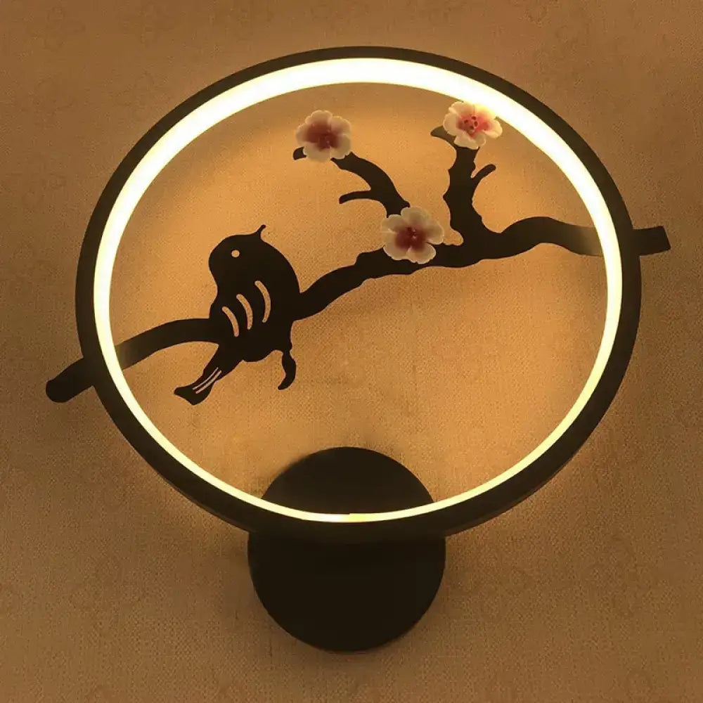 Decorbites white circular LED sconce with black ring, bird on branch silhouette and blossoms, warm glow on Tampa Home & Garden Store