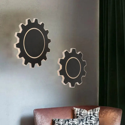 Black gear-shaped wall sconces with white trim and inner rings, acrylic decor above a sofa on Tampa Home & Garden Store