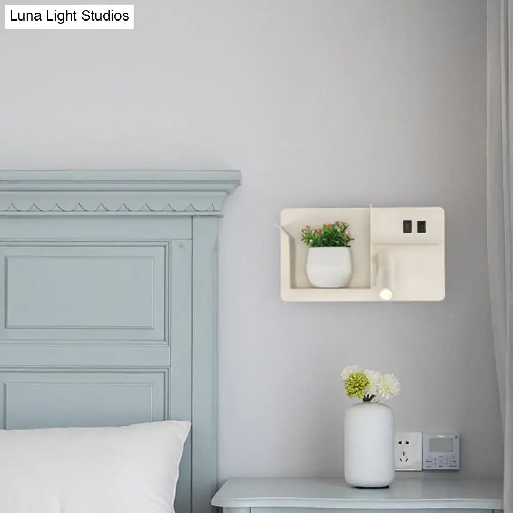 Black tubular wall light mounted on a gray wall near a white shelf with a potted plant on Tampa Home & Garden Store