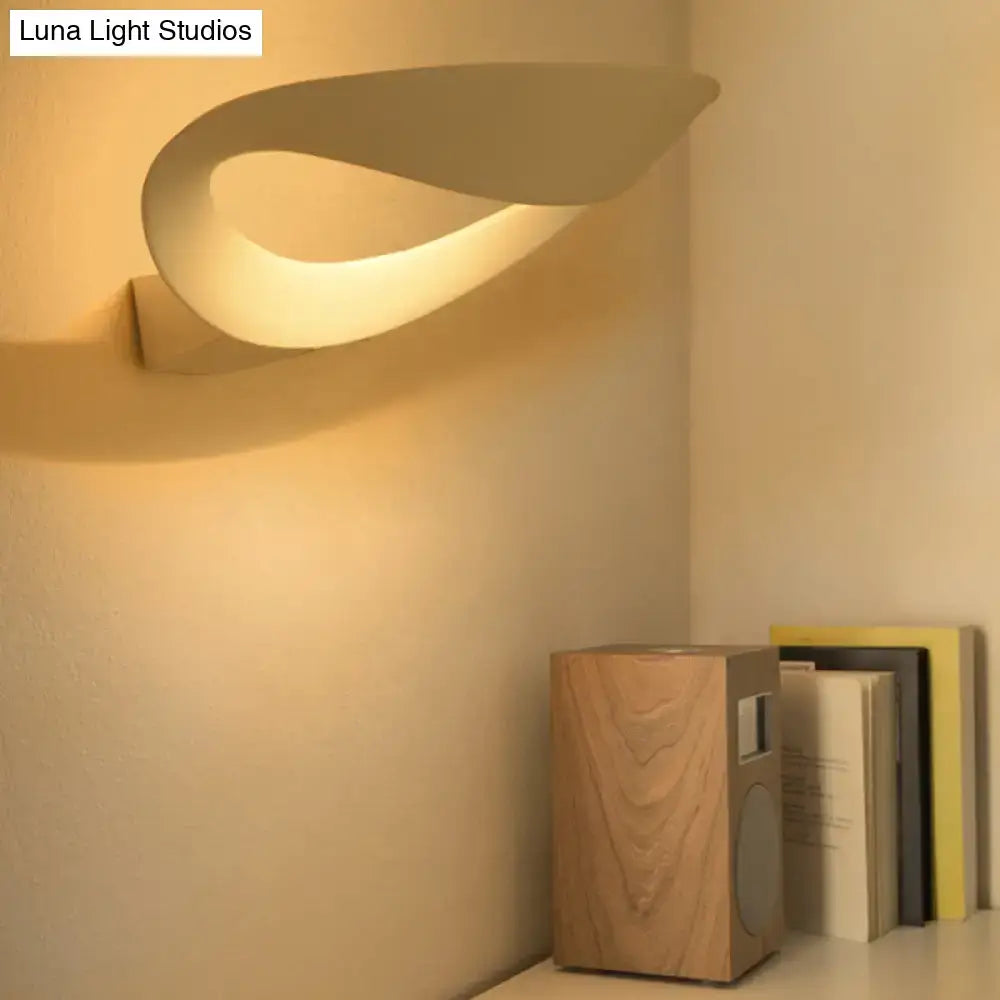 Black oval aluminum LED wall sconce with looping curved shade warm ambient glow on Tampa Home & Garden Store