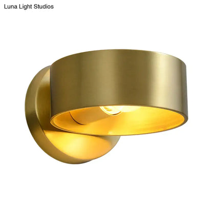 Brass curved wall lamp with round backplate and warm amber glow on Tampa Home & Garden Store