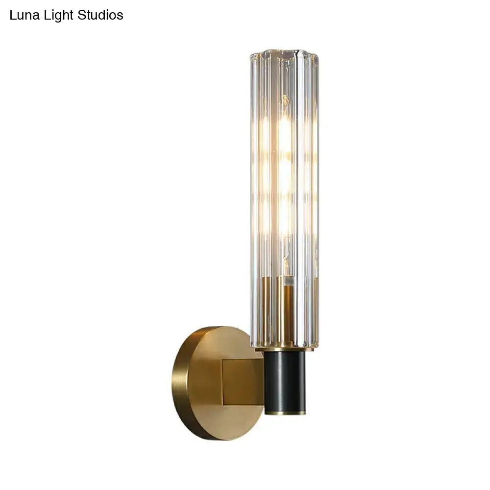 Brass tubular wall sconce with clear vertical glass tubes and warm glow by Decorbites on Tampa Home & Garden Store
