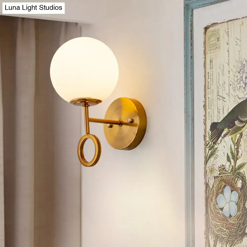 Brass cream glass wall sconce by Decorbites with round globe shade and ring detail on Tampa Home & Garden Store