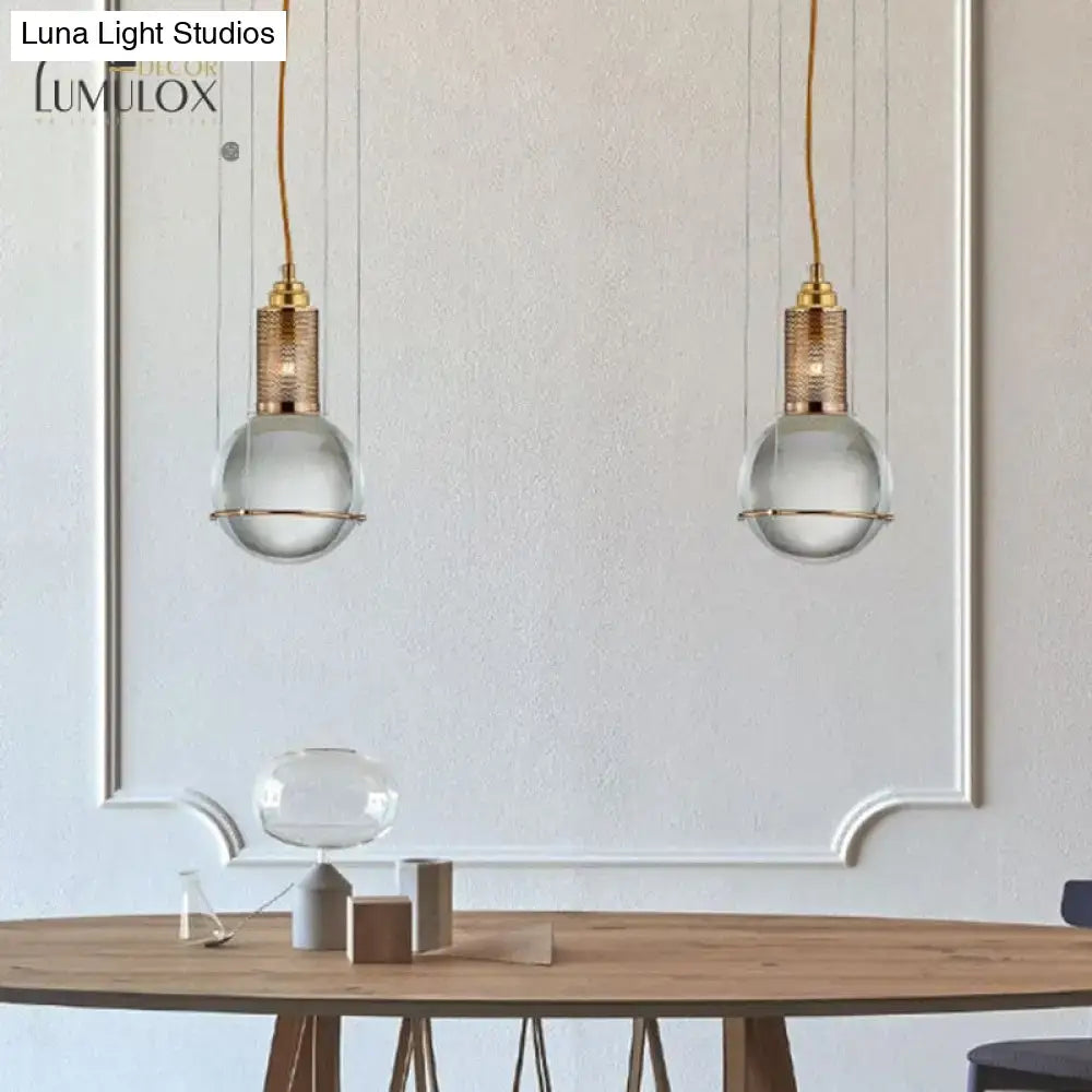 Brass Crystal Globe Pendant Lights pair with clear glass globes and brass tops over a wooden table on Tampa Home & Garden Store