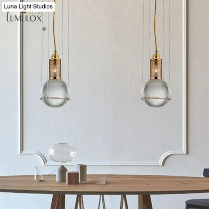 Brass Crystal Globe Pendant Lights pair with clear glass globes and brass tops over a wooden table on Tampa Home & Garden Store